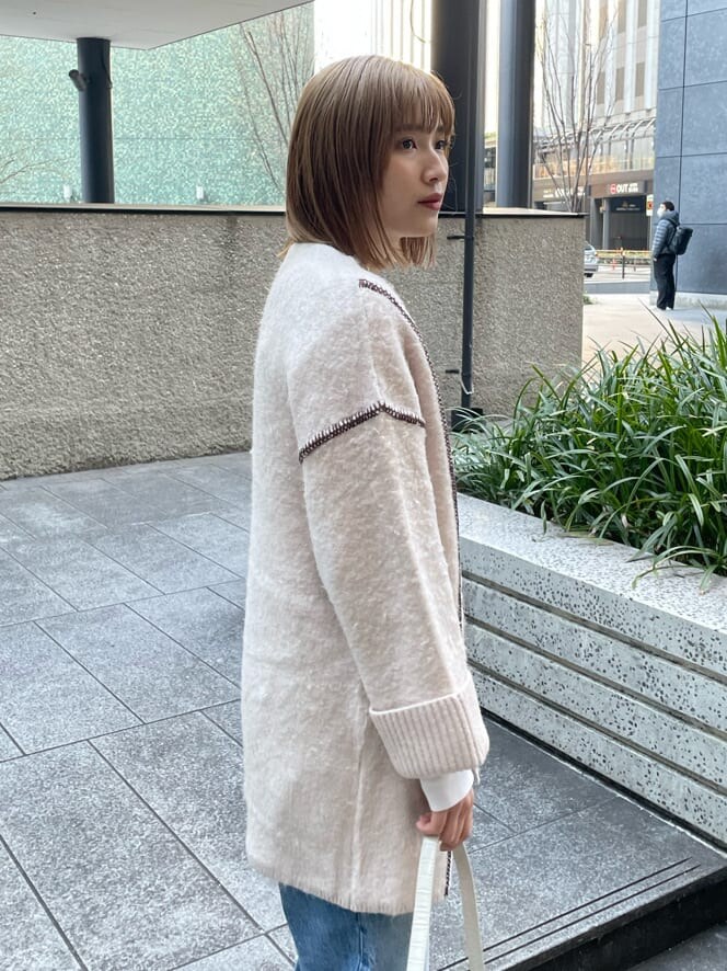 ホワイト系のハンドバッグ、ホワイト系のカーディガン/ボレロを着用したレディースの冬コーディネートの2枚目の写真