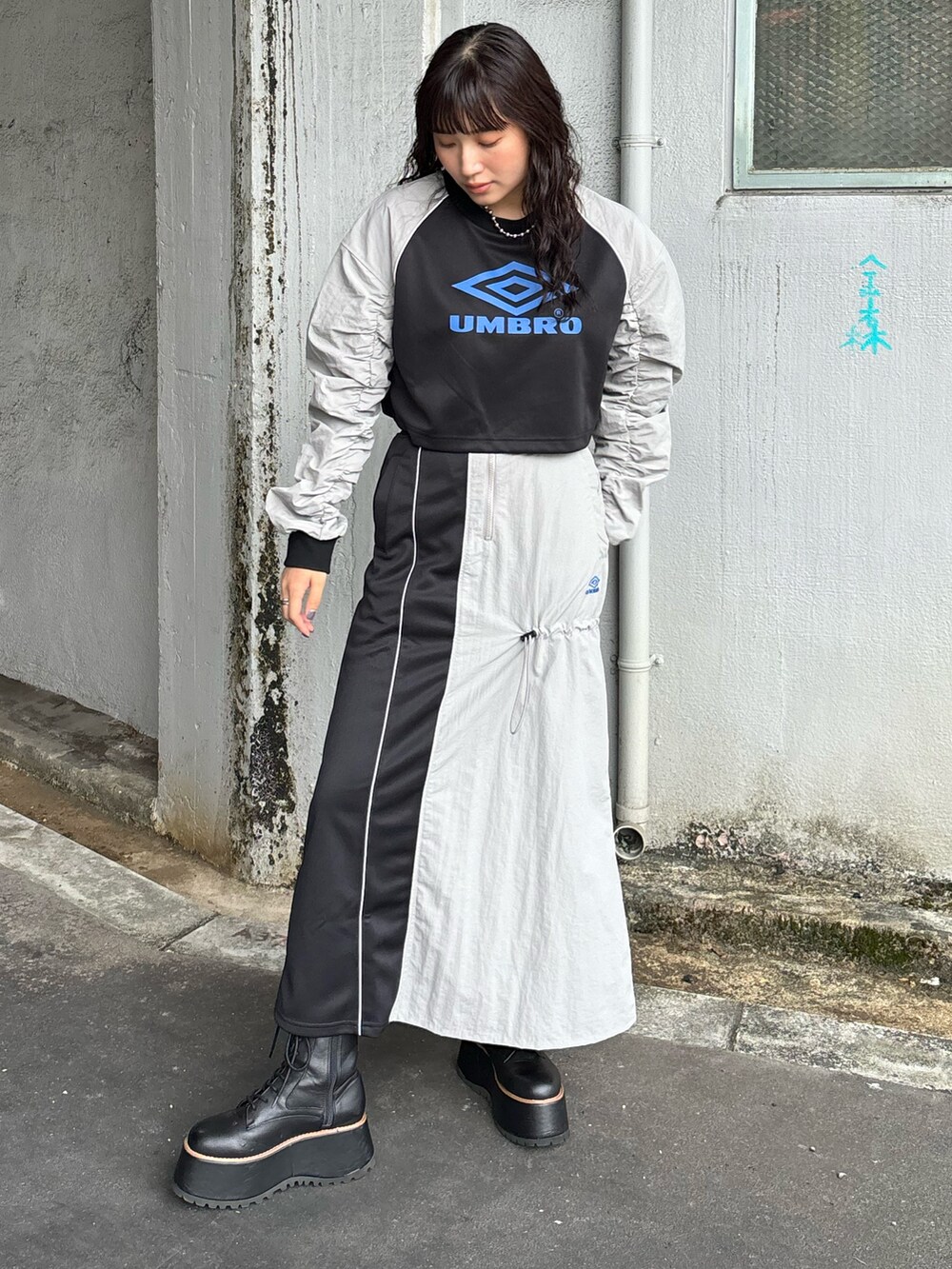 グレー系のTシャツ/カットソー、グレー系のスカートを着用したレディースの秋コーディネートの2枚目の写真