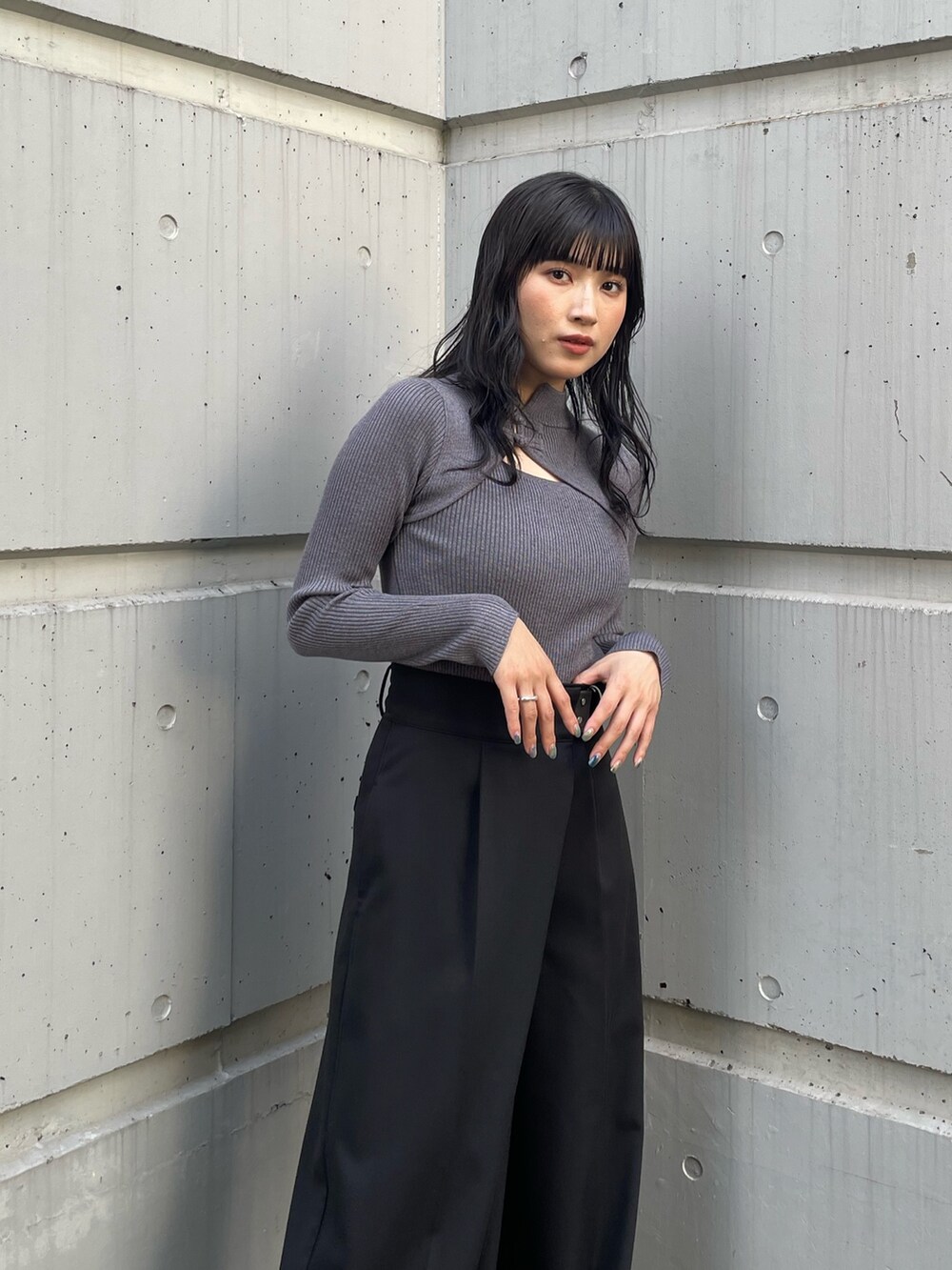 グレー系のニット/セーター、ベージュ系のスラックス、その他のブーツを着用したレディースの夏コーディネートの3枚目の写真