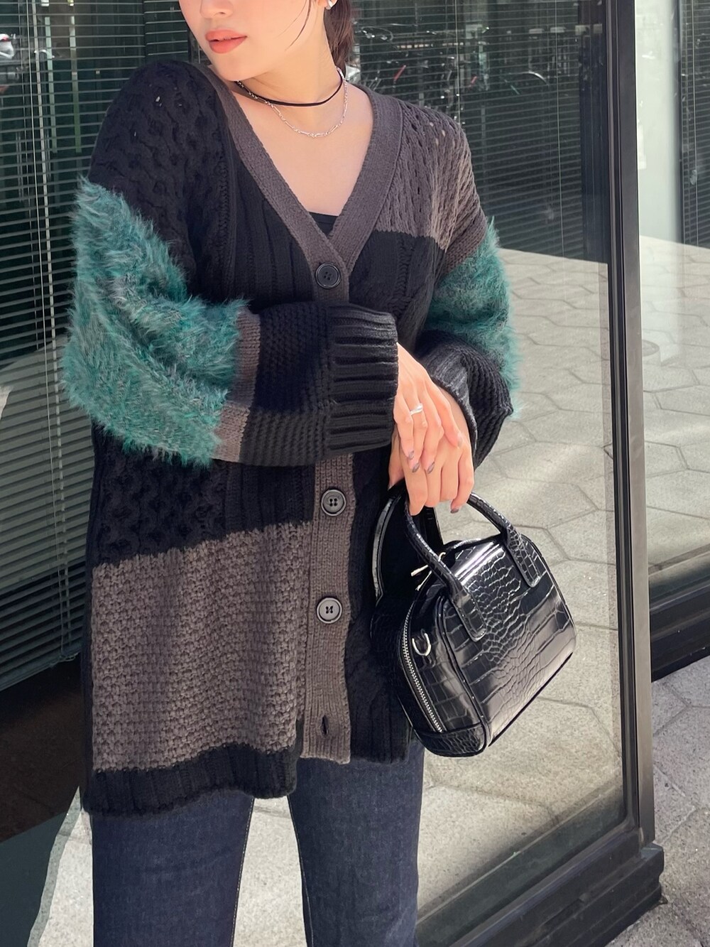 ブラック系のカーディガン/ボレロ、ブルー系のデニムパンツを着用したレディースの秋コーディネートの2枚目の写真