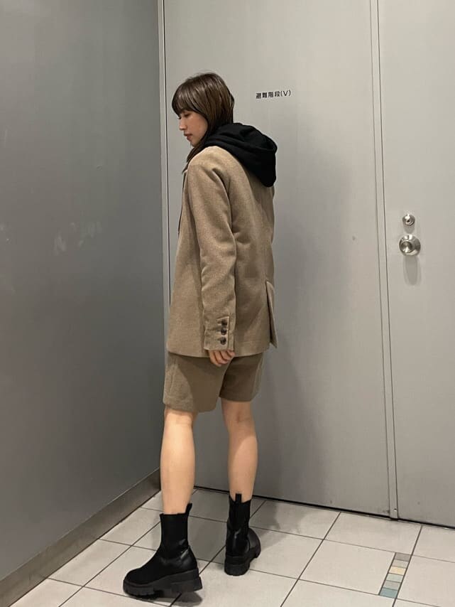 ブラック系のブーツ、ブラウン系のテーラードジャケット、ブラウン系のスラックスを着用したレディースの秋コーディネートの3枚目の写真