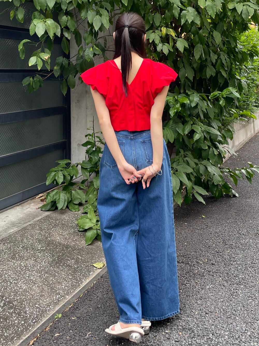 レッド系のシャツ/ブラウス、ブルー系のデニムパンツを着用したレディースの夏コーディネートの2枚目の写真