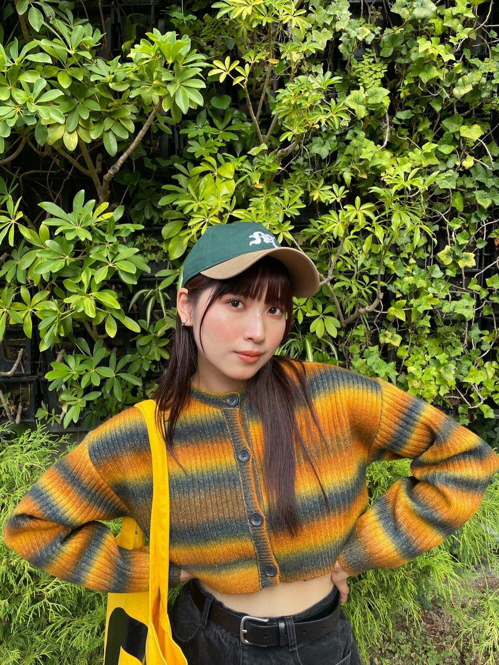 イエロー系のカーディガン/ボレロ、グリーン系のキャップを着用したレディースの秋コーディネートの4枚目の写真