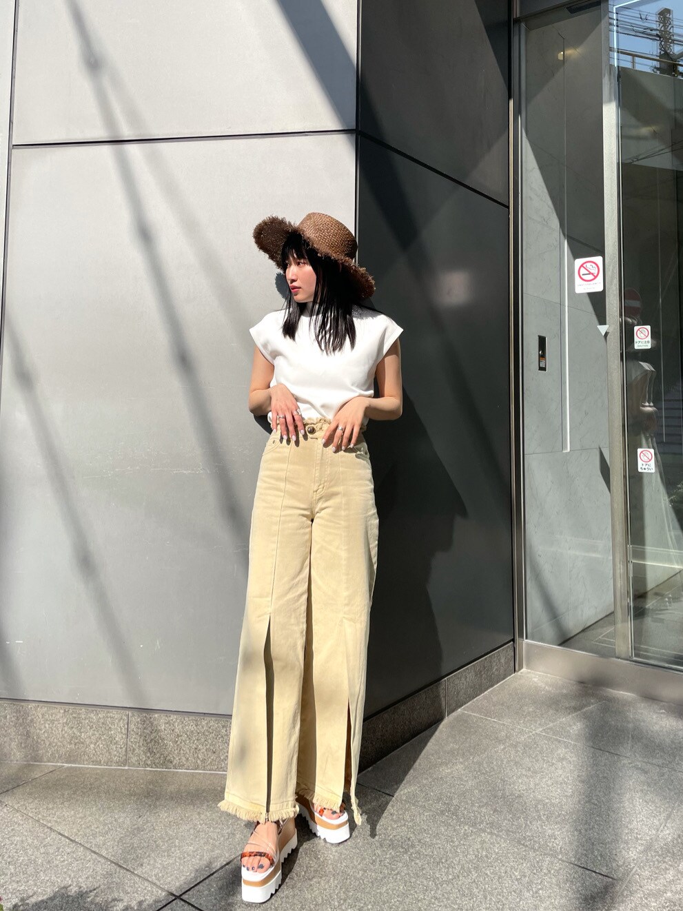 ホワイト系のTシャツ/カットソー、イエロー系のその他パンツ、ホワイト系のサンダルを着用したレディースの春コーディネートの2枚目の写真