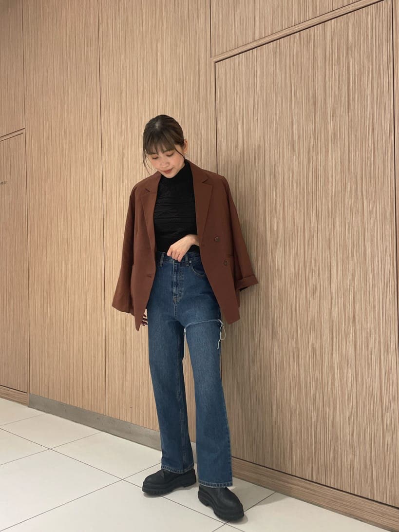 ブラウン系のテーラードジャケット、ブルー系のデニムパンツ、ブラック系のニット/セーターを着用したレディースの夏コーディネートの2枚目の写真