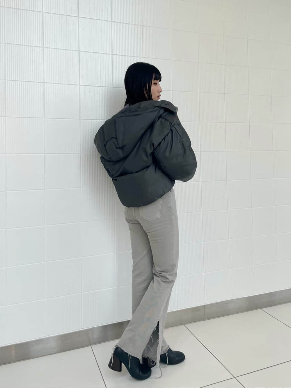 ブラック系のブーツ、グレー系のダウンジャケット/コート、グレー系のデニムパンツを着用したレディースの秋コーディネートの2枚目の写真