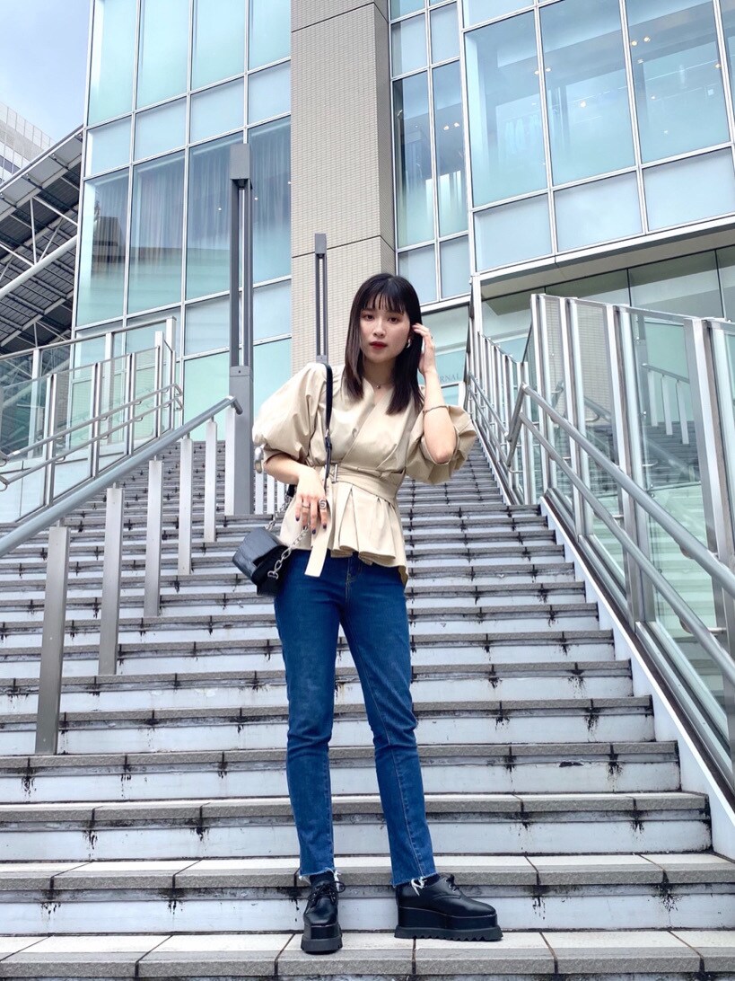 ベージュ系のシャツ/ブラウス、ブルー系のデニムパンツ、ブラック系のハンドバッグを着用したレディースの春コーディネートの3枚目の写真