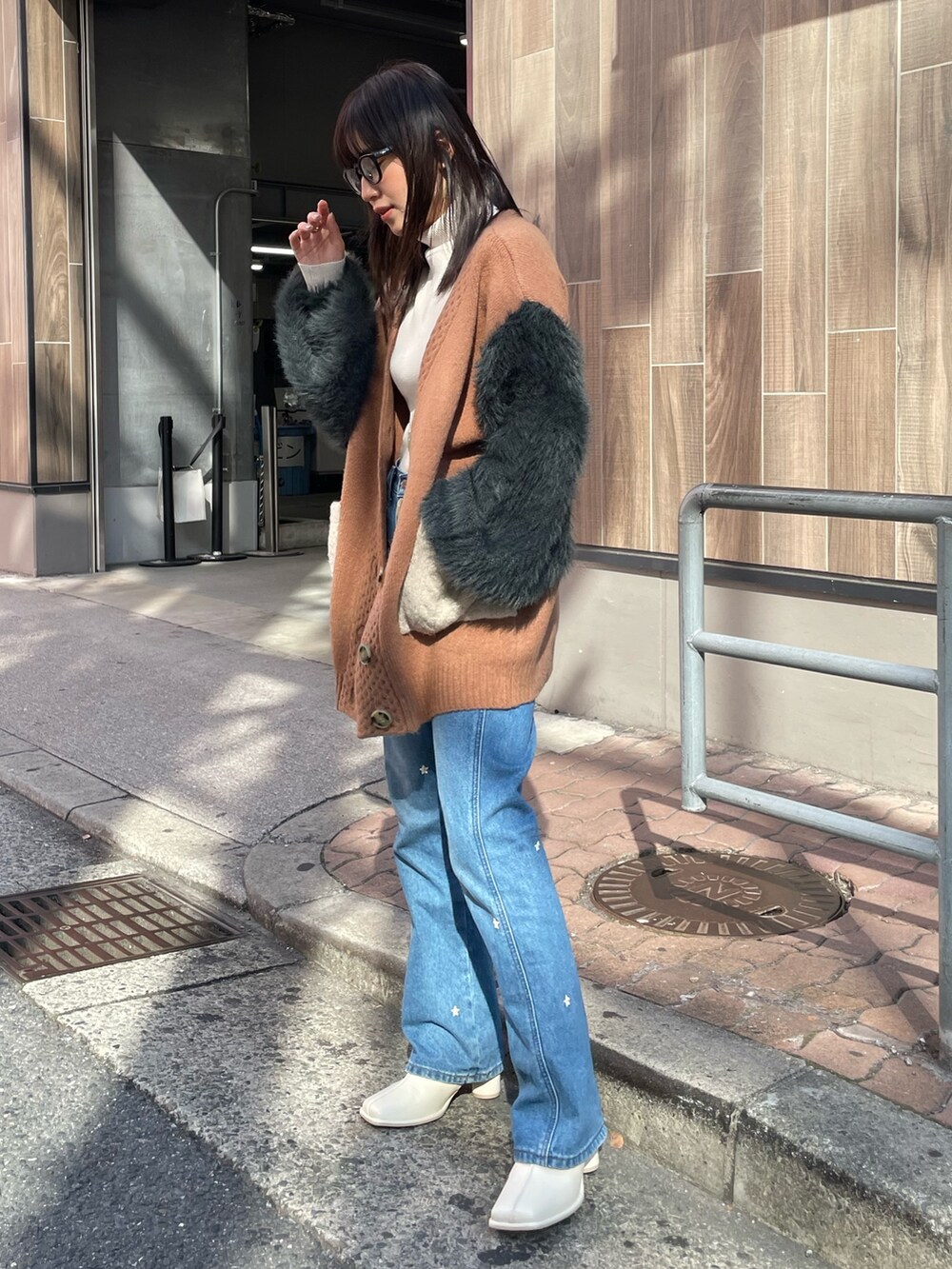 ブラウン系のカーディガン/ボレロ、ホワイト系のニット/セーター、ホワイト系のブーツを着用したレディースの秋コーディネートの2枚目の写真