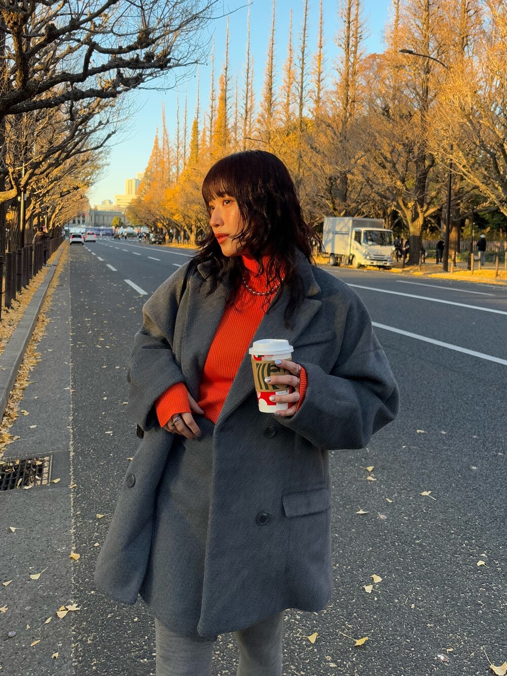 グレー系のテーラードジャケット、グレー系のスカート、ブラック系のボストンバッグを着用したレディースの冬コーディネートの3枚目の写真