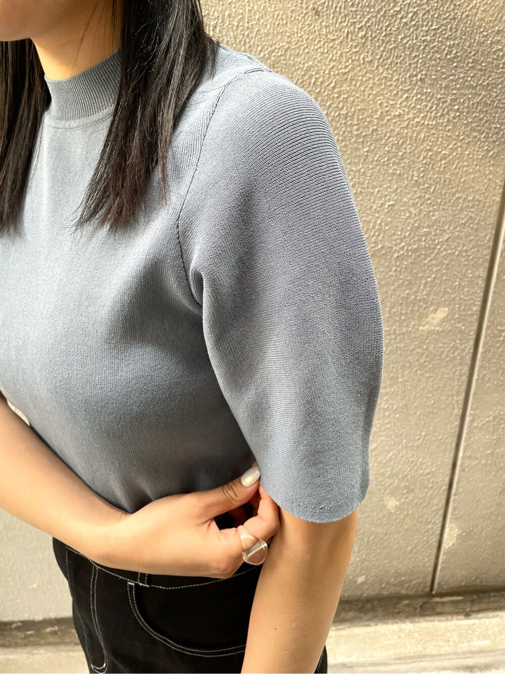 ブラック系のスカート、ブラック系のサンダル、ブルー系のニット/セーターを着用したレディースの春コーディネートの4枚目の写真