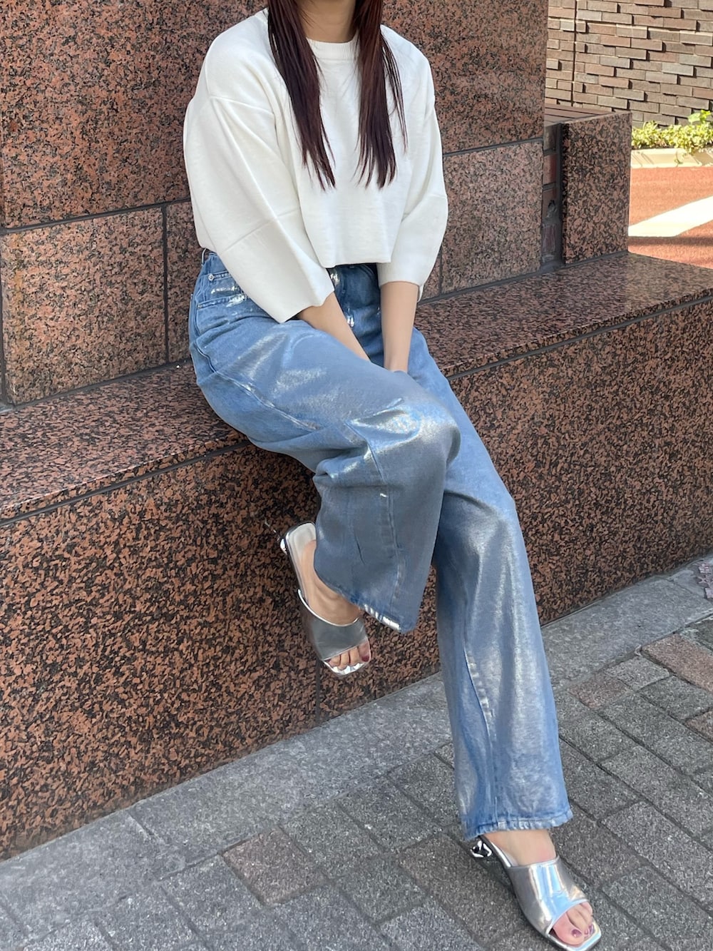 ホワイト系のニット/セーター、ブルー系のデニムパンツを着用したレディースの冬コーディネートの4枚目の写真