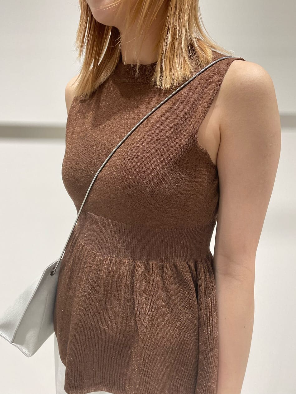 ホワイト系のデニムパンツ、ブラウン系のワンピース、ホワイト系のショルダーバッグを着用したレディースの春コーディネートの5枚目の写真