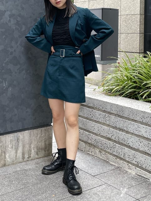 グリーン系のテーラードジャケット、グリーン系のスカート、ブラック系のニット/セーターを着用したレディースの夏コーディネートの4枚目の写真