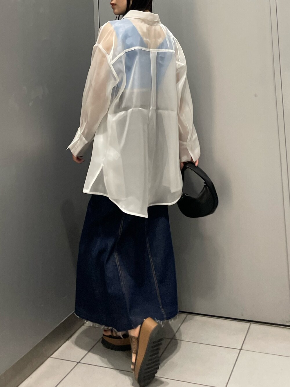 ホワイト系のシャツ/ブラウス、ブルー系のタンクトップ、ブルー系のデニムスカートを着用したレディースの春コーディネートの3枚目の写真