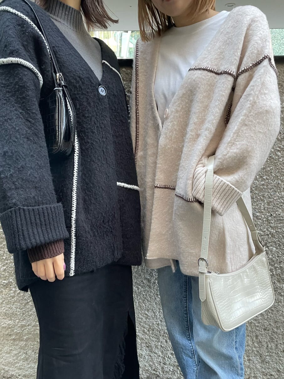 ホワイト系のハンドバッグ、ホワイト系のカーディガン/ボレロを着用したレディースの冬コーディネートの4枚目の写真