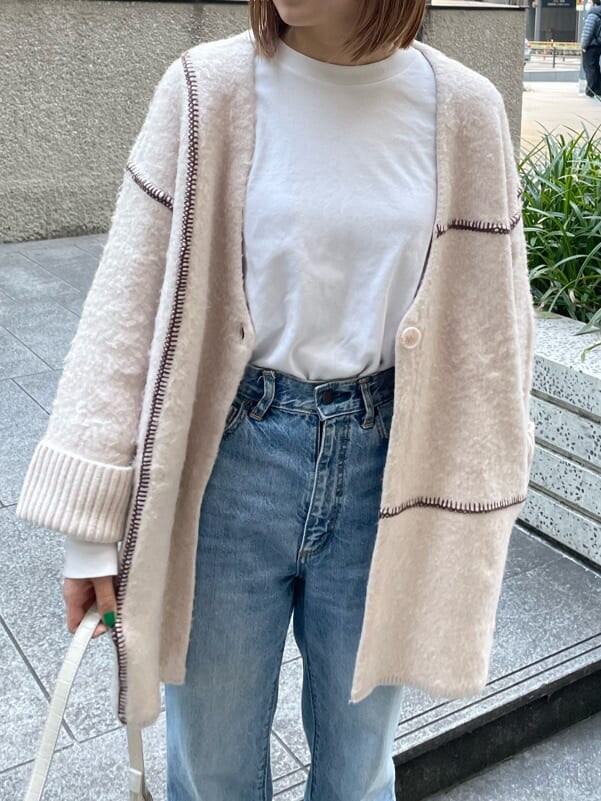 ホワイト系のハンドバッグ、ホワイト系のカーディガン/ボレロを着用したレディースの冬コーディネートの3枚目の写真