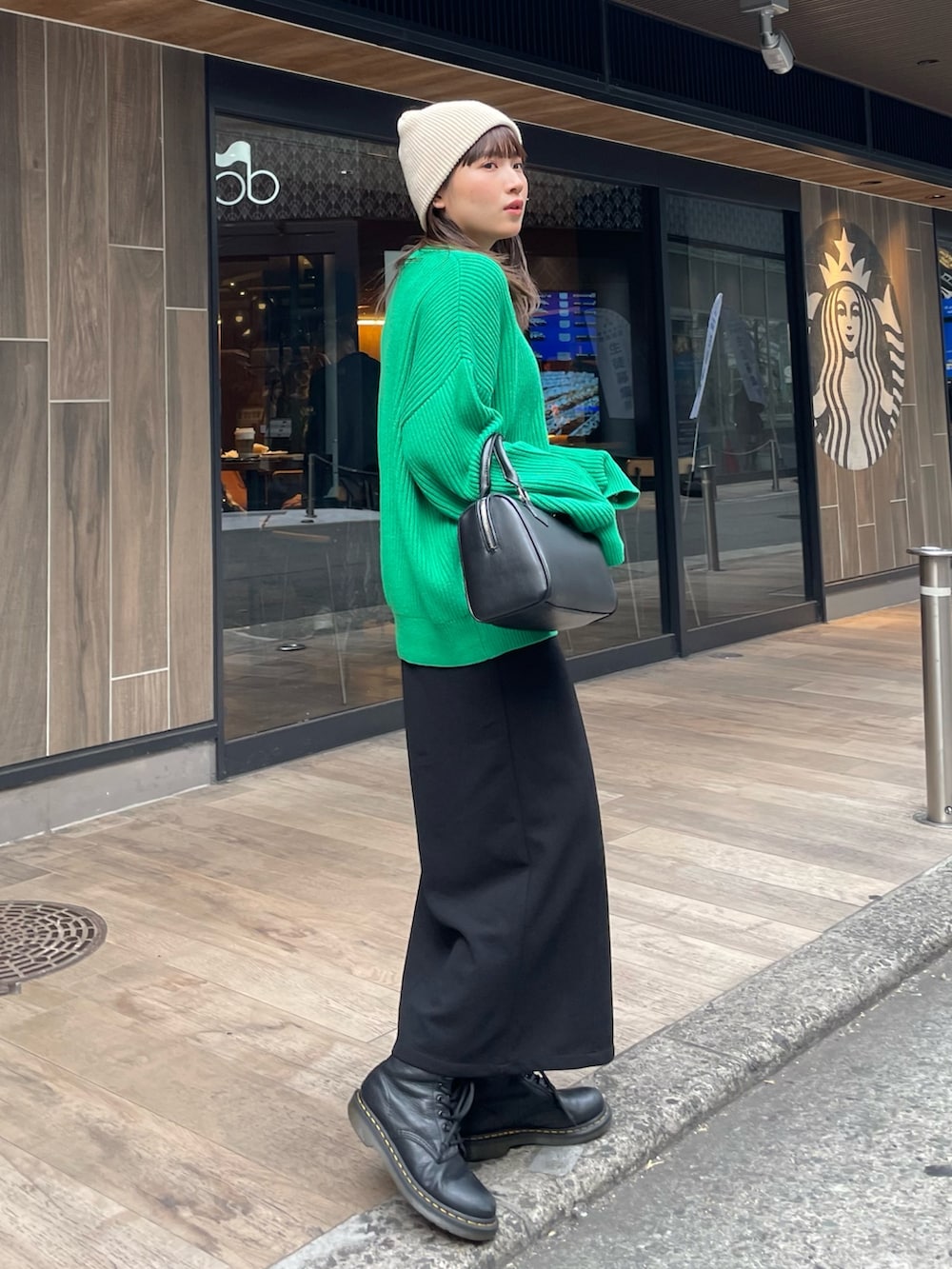 グリーン系のニット/セーター、ブラック系のスカートを着用したレディースの冬コーディネートの5枚目の写真