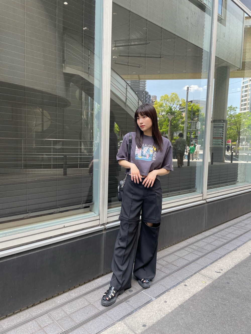 ブラック系のスラックス、ホワイト系のTシャツ/カットソーを着用したレディースの春コーディネートの3枚目の写真