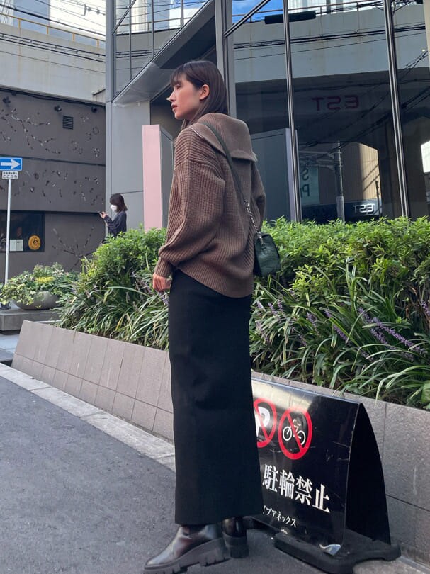 ブラック系のブーツ、ブラウン系のニット/セーター、グリーン系のショルダーバッグを着用したレディースの秋コーディネートの3枚目の写真