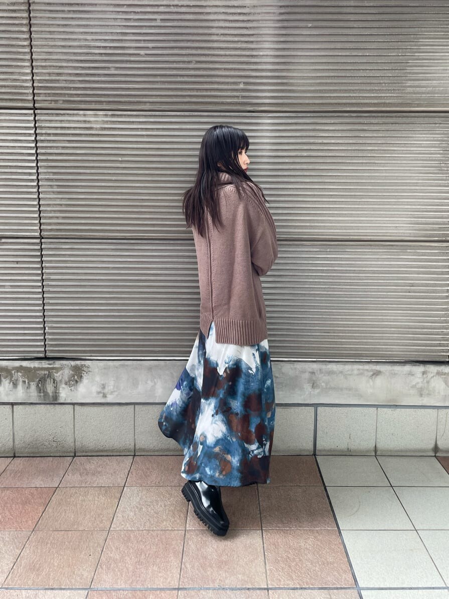 ベージュ系のニット/セーター、ブラック系のダウンジャケット/コート、ブルー系のスカートを着用したレディースの秋コーディネートの4枚目の写真