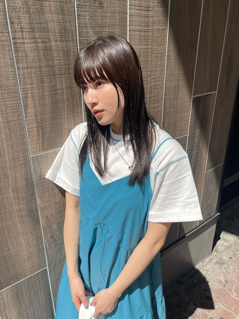 ブルー系のワンピース、ホワイト系のTシャツ/カットソー、シルバー系のネックレスを着用したレディースの春コーディネートの6枚目の写真