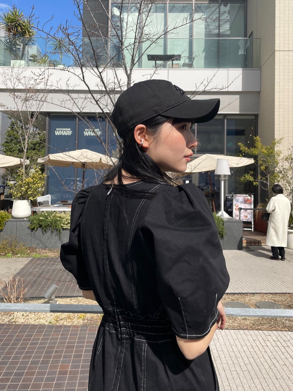 ブラック系のワンピースを着用したレディースの春コーディネートの3枚目の写真