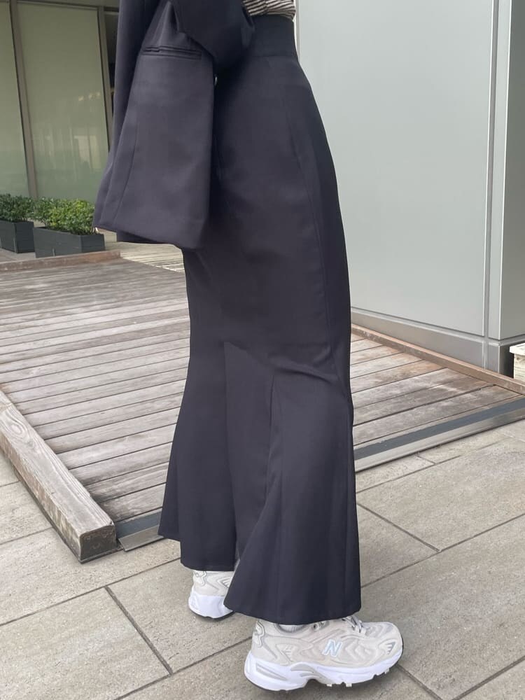 ブラック系のテーラードジャケット、ホワイト系のハンドバッグ、ブラック系のスカートを着用したレディースの春コーディネートの8枚目の写真