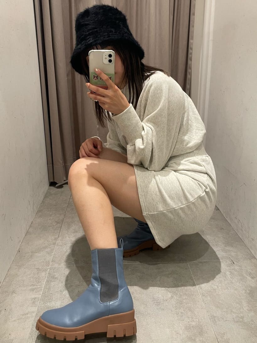 ホワイト系のワンピース、ブルー系のブーツ、ブラック系のハットを着用したレディースの秋コーディネートの5枚目の写真