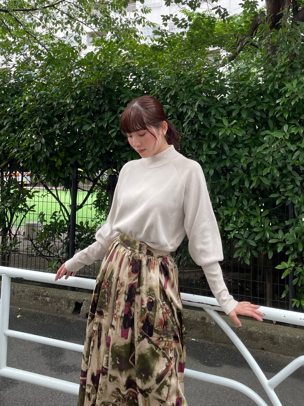 ホワイト系のニット/セーター、グリーン系のスカートを着用したレディースの夏コーディネートの2枚目の写真