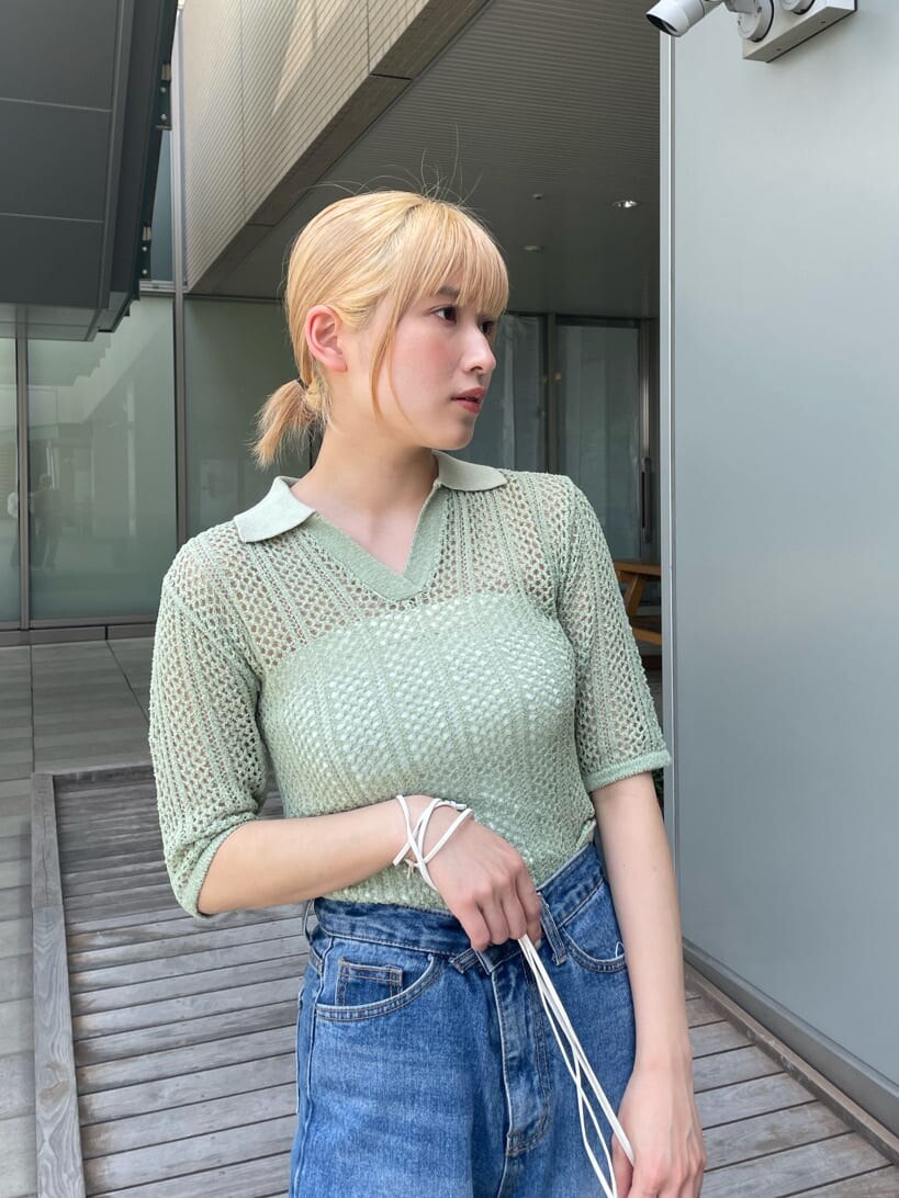 ホワイト系のサンダル、ホワイト系のハンドバッグ、グリーン系のポロシャツを着用したレディースの春コーディネートの4枚目の写真