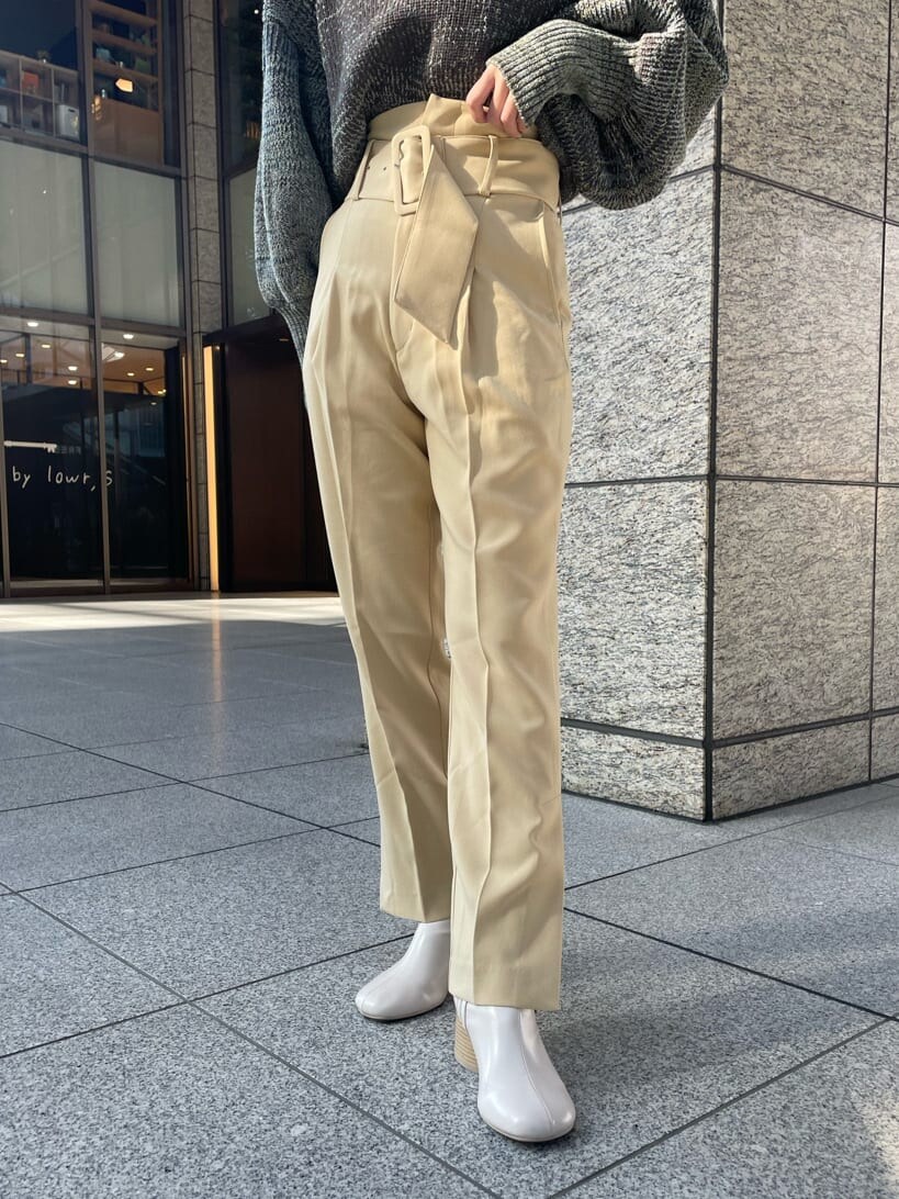 ホワイト系のブーツ、イエロー系のスラックス、ブラウン系のニット/セーターを着用したレディースの冬コーディネートの4枚目の写真