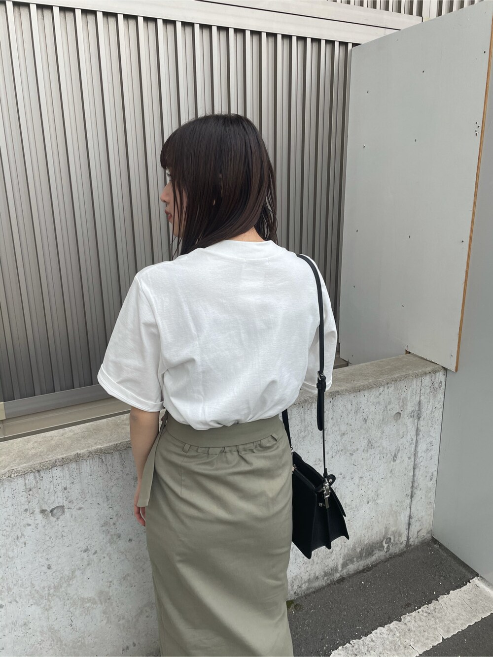 ベージュ系のスカート、ブラック系のサンダル、ホワイト系のTシャツ/カットソーを着用したレディースの春コーディネートの6枚目の写真