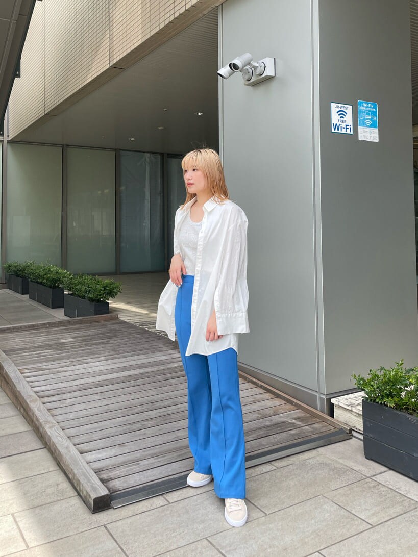 ベージュ系のスニーカー、ホワイト系のシャツ/ブラウス、ブルー系のスラックスを着用したレディースの春コーディネートの2枚目の写真