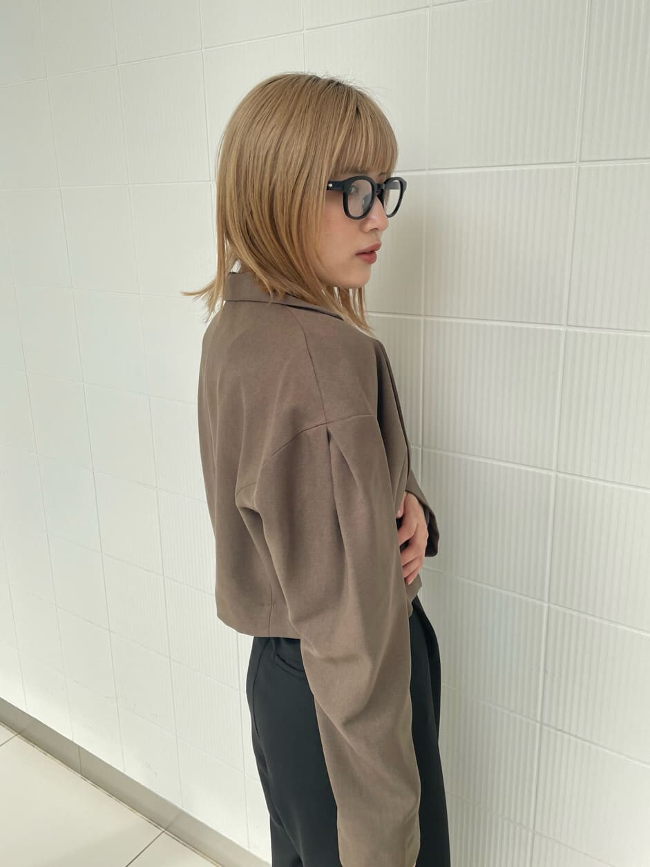 ブラック系のブーツ、ブラック系のスラックス、ブラウン系のテーラードジャケットを着用したレディースの春コーディネートの6枚目の写真