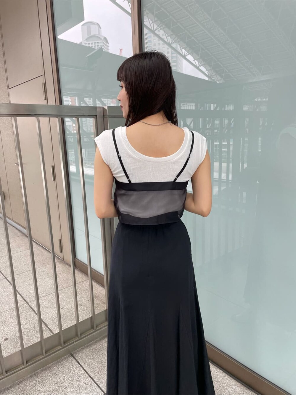 ブラック系のサンダル、ブラック系のスカート、ブラック系のTシャツ/カットソーを着用したレディースの夏コーディネートの5枚目の写真