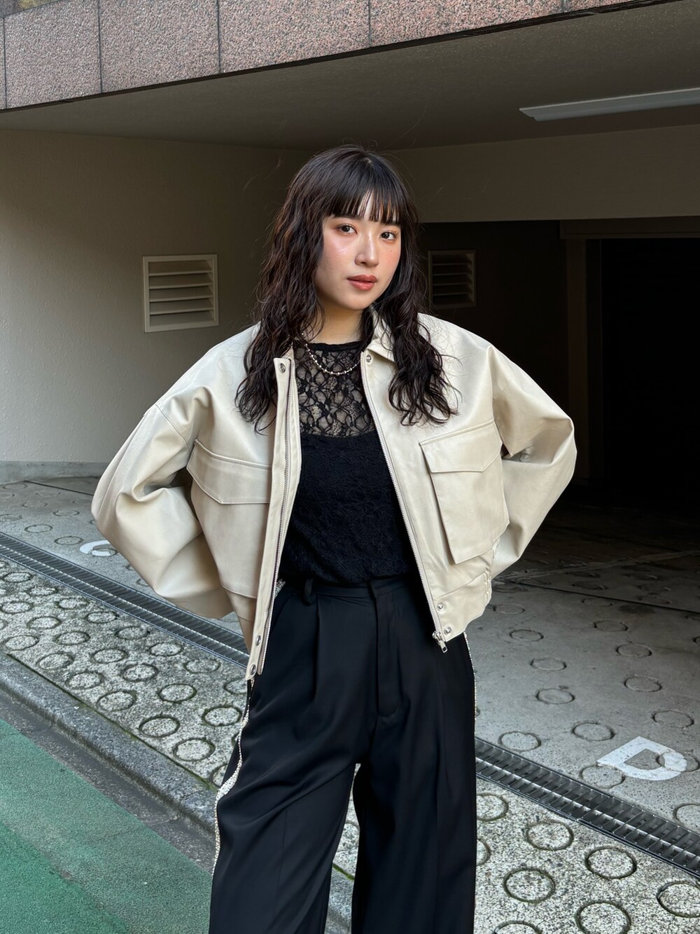 ホワイト系のブルゾン、ブラック系のその他パンツを着用したレディースの秋コーディネートの3枚目の写真