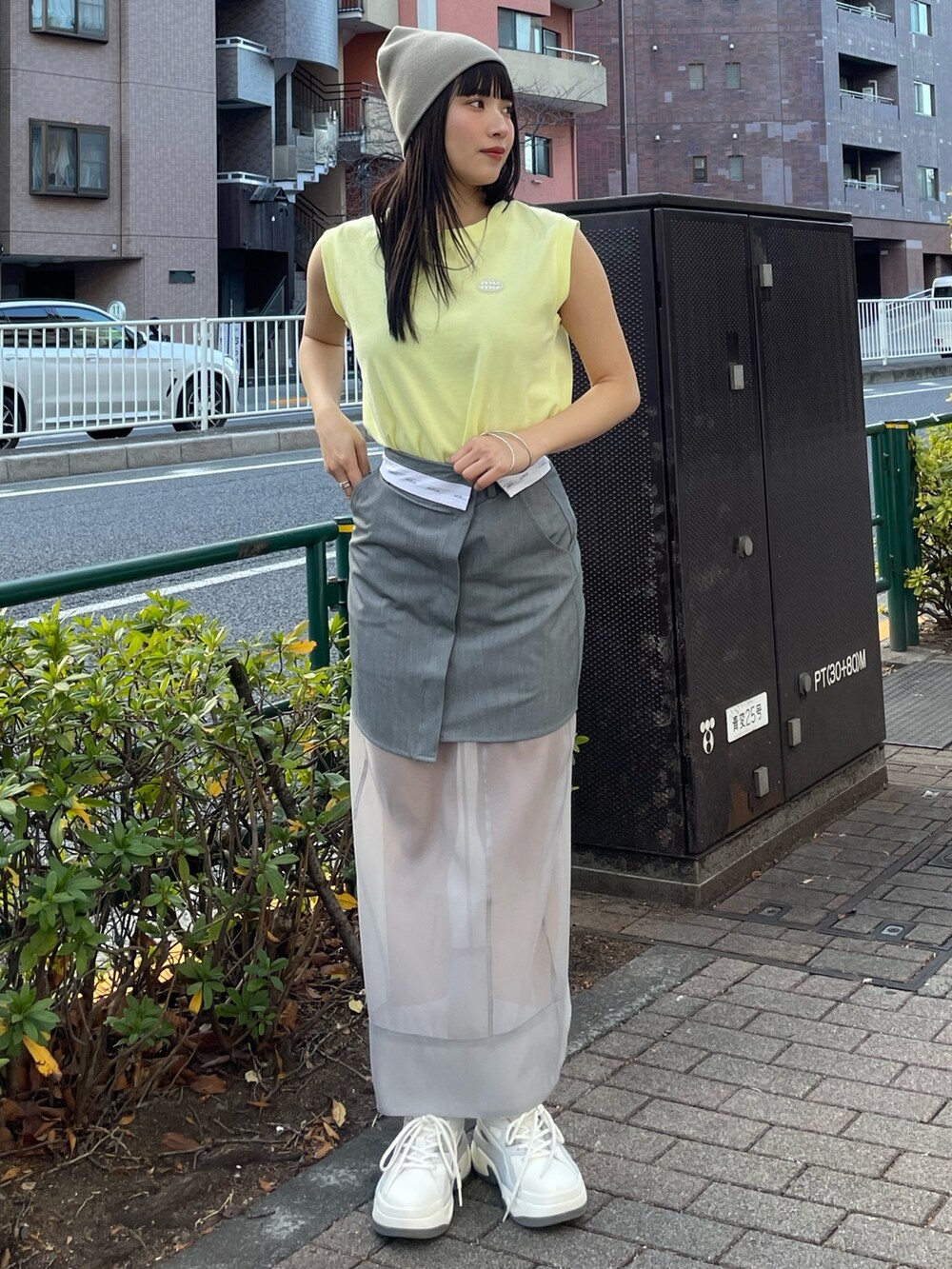 グレー系のスニーカー、イエロー系のタンクトップを着用したレディースの冬コーディネートの2枚目の写真