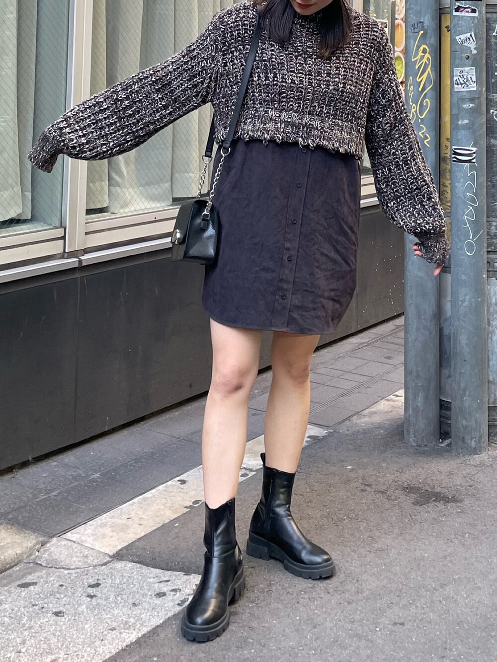 ブラック系のワンピース、ブラック系のブーツ、ブラック系のショルダーバッグを着用したレディースの秋コーディネートの2枚目の写真