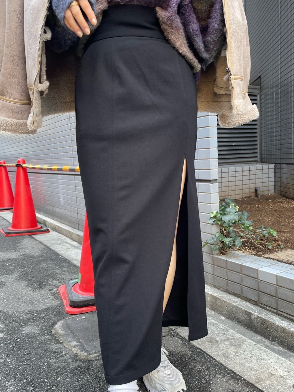 ベージュ系のムートンコート、パープル系のニット/セーター、ブラック系のスカートを着用したレディースの秋コーディネートの7枚目の写真