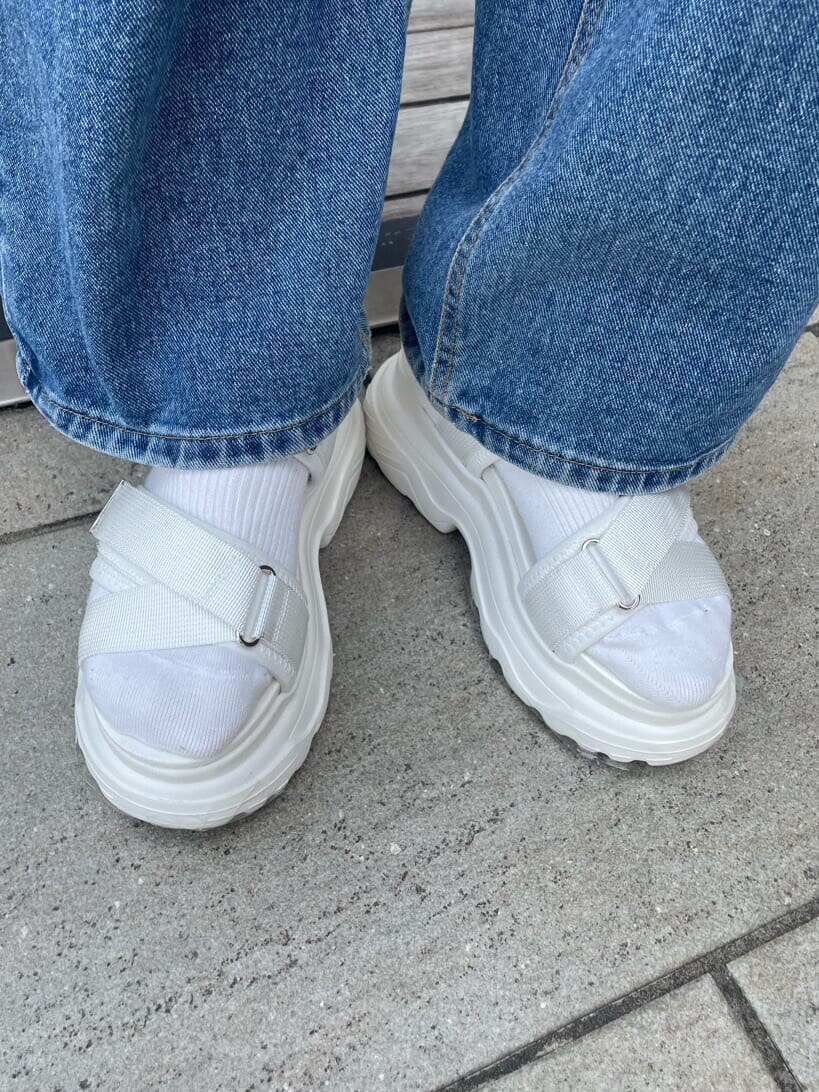 ホワイト系のサンダル、ホワイト系のハンドバッグ、グリーン系のポロシャツを着用したレディースの春コーディネートの8枚目の写真