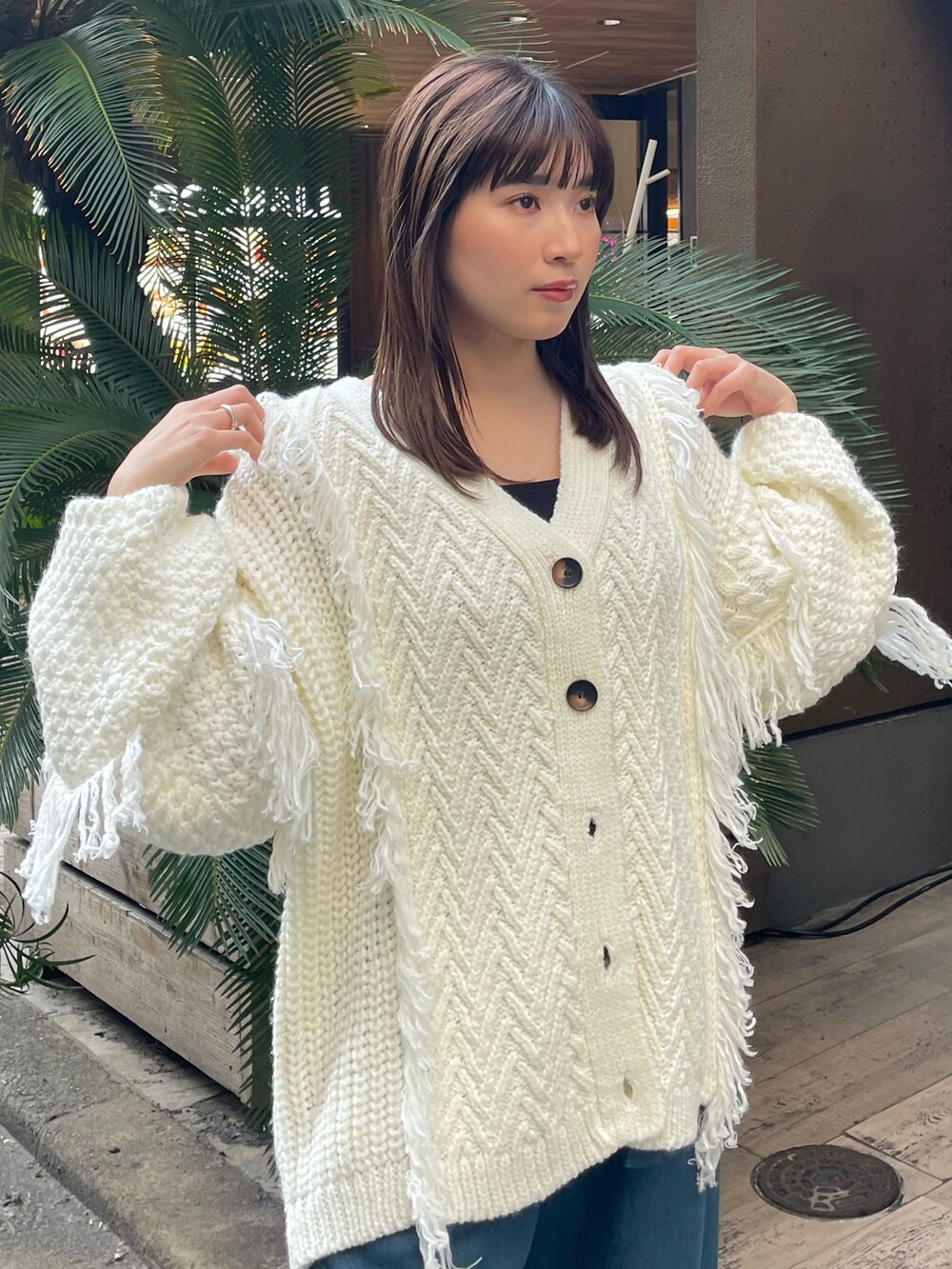 ホワイト系のカーディガン/ボレロ、ブルー系のスラックスを着用したレディースの冬コーディネートの5枚目の写真