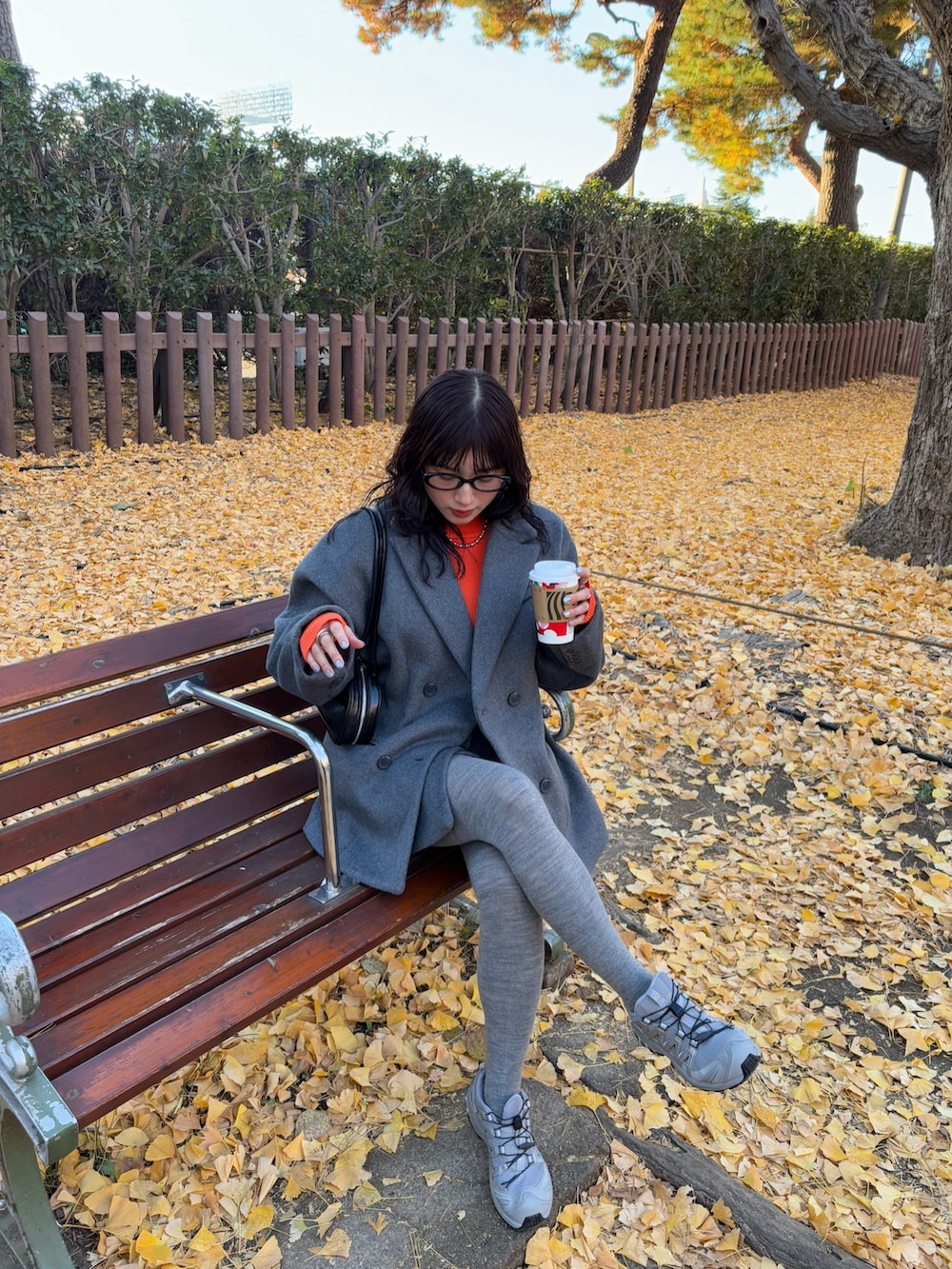 グレー系のテーラードジャケット、グレー系のスカート、ブラック系のボストンバッグを着用したレディースの冬コーディネートの4枚目の写真