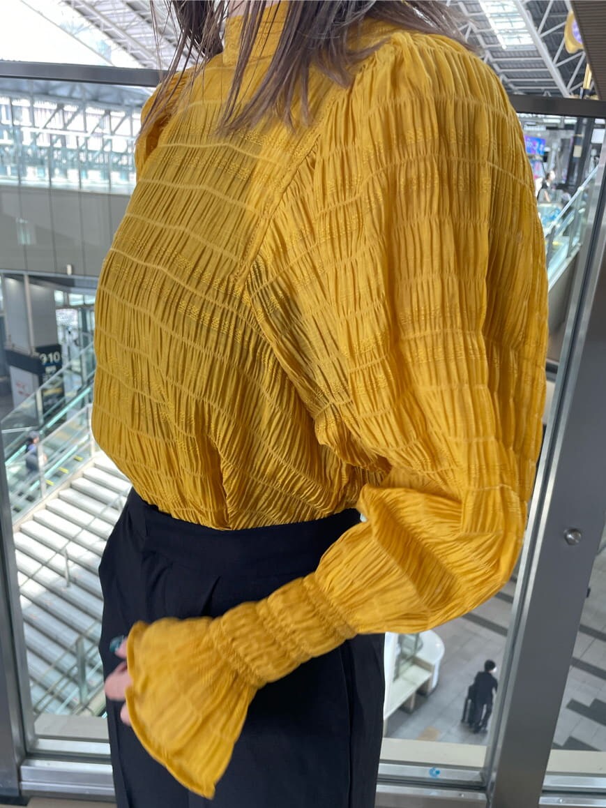 イエロー系のシャツ/ブラウス、ホワイト系のブーツ、ブラック系のスラックスを着用したレディースの夏コーディネートの5枚目の写真