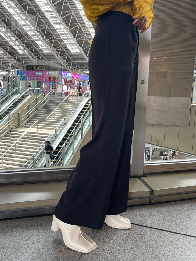 イエロー系のシャツ/ブラウス、ホワイト系のブーツ、ブラック系のスラックスを着用したレディースの夏コーディネートの7枚目の写真