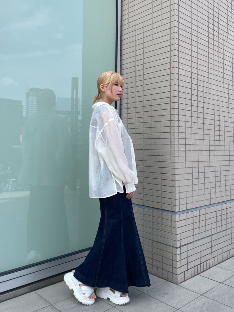 ブルー系のタンクトップ、ブルー系のデニムスカート、ホワイト系のサンダルを着用したレディースの春コーディネートの2枚目の写真