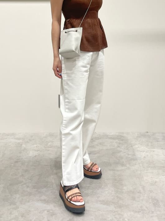 ホワイト系のデニムパンツ、ブラウン系のワンピース、ホワイト系のショルダーバッグを着用したレディースの春コーディネートの6枚目の写真