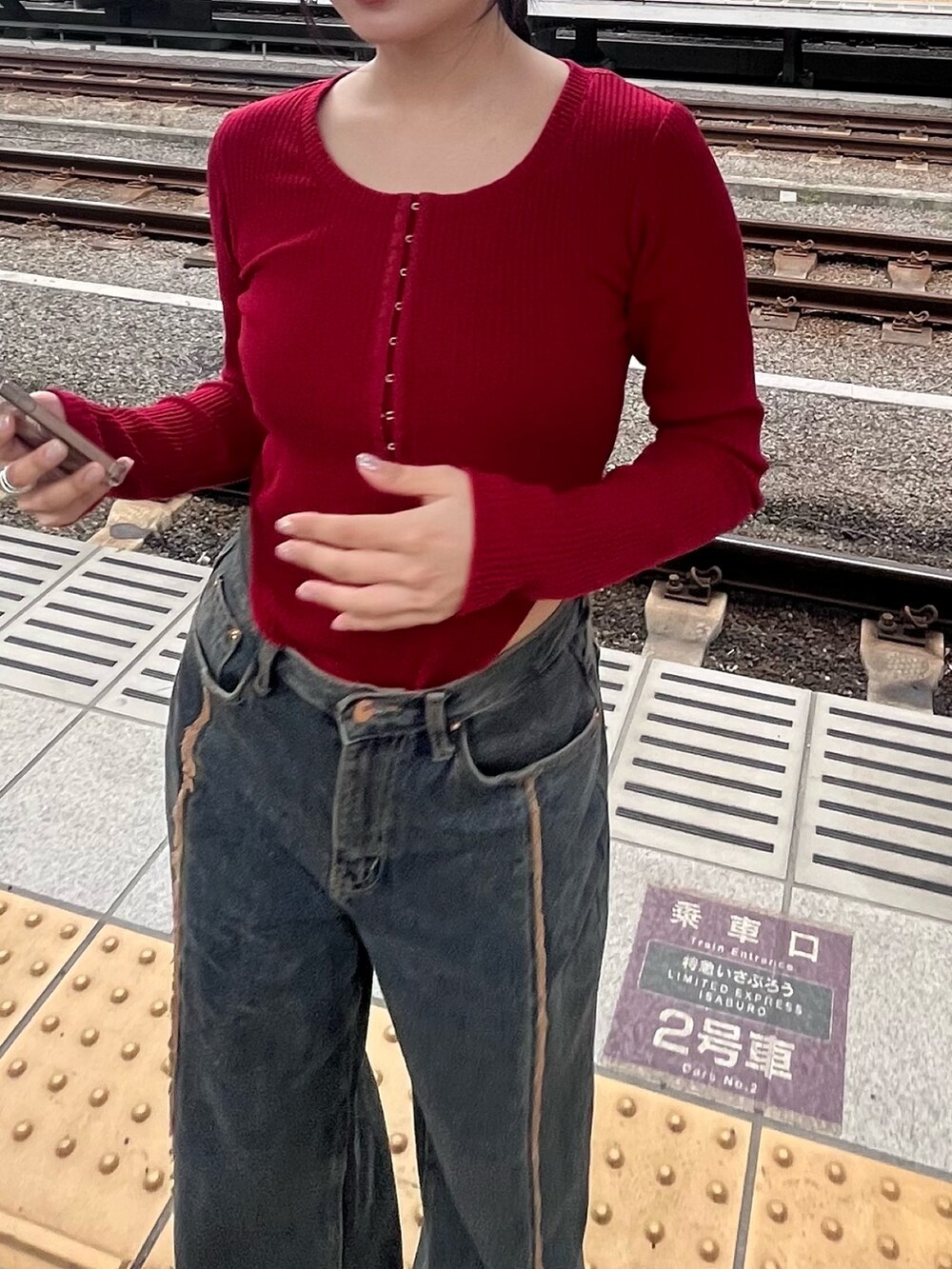 レッド系のTシャツ/カットソーを着用したレディースの冬コーディネートの3枚目の写真
