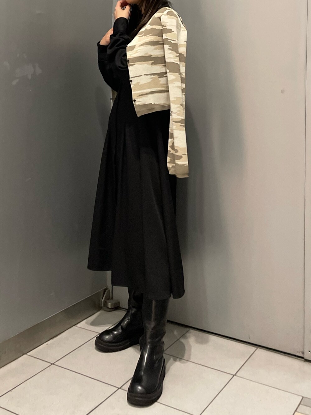 ベージュ系のカーディガン/ボレロ、ブラック系のワンピースを着用したレディースの冬コーディネートの2枚目の写真