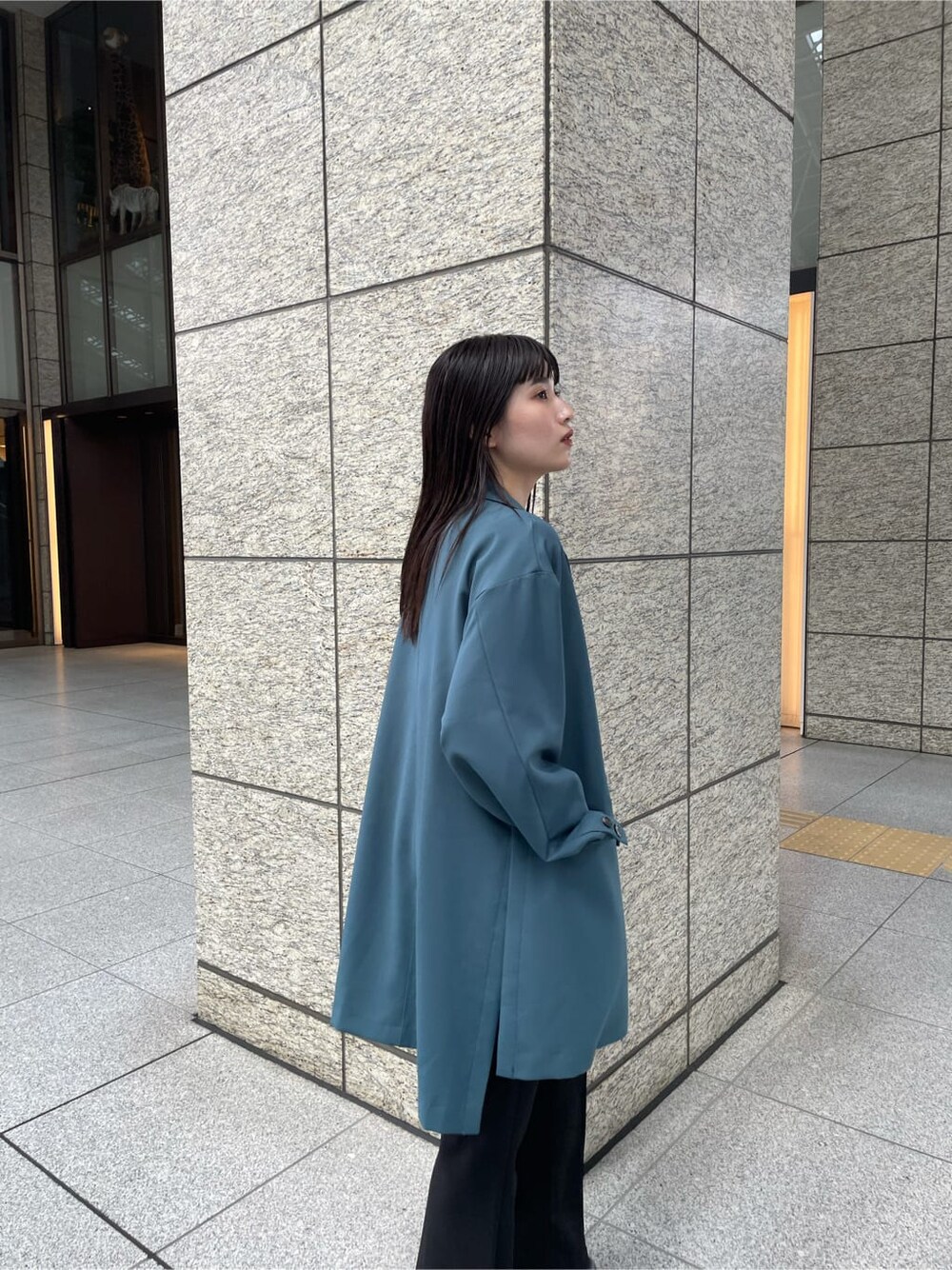 グリーン系のテーラードジャケット、ブラック系のその他パンツ、ブラック系のブーツを着用したレディースの秋コーディネートの5枚目の写真