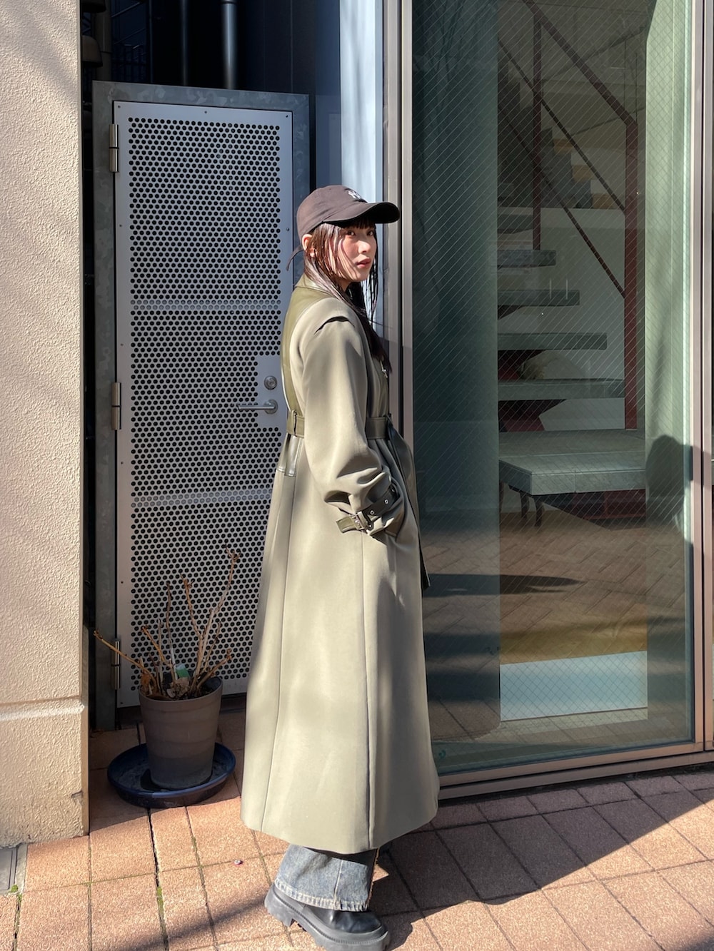 グリーン系のトレンチコートを着用したレディースの冬コーディネートの3枚目の写真